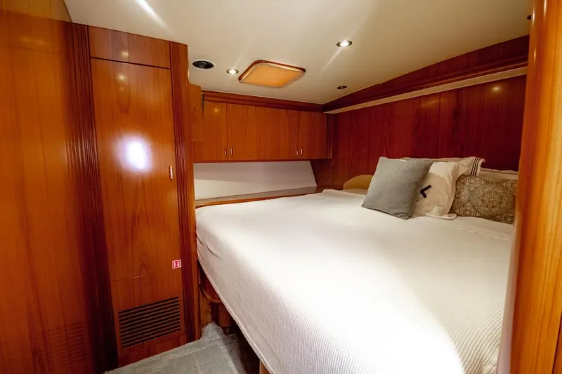 Reel Deal Yacht Photos Pics Luxurious cabin interior of 2005 Sea Force Sportfish yacht with wood paneling and cozy bedding.