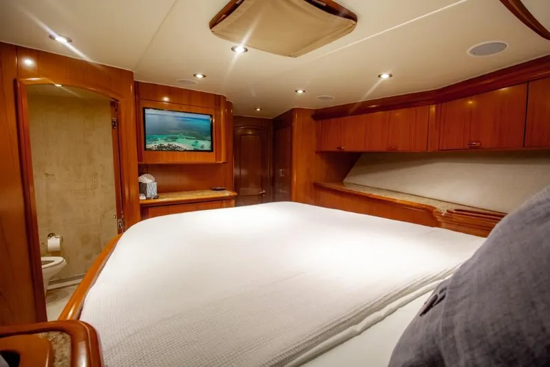 Reel Deal Yacht Photos Pics Luxurious cabin interior of 2005 Sea Force Sportfish yacht with wood finish and cozy bedding.