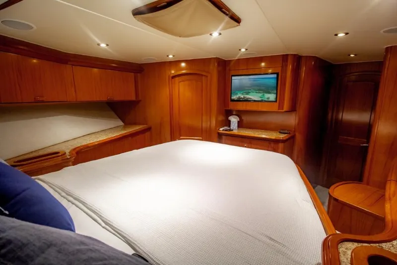 Reel Deal Yacht Photos Pics Luxurious cabin interior of 2005 Sea Force Sportfish yacht with wood finish and cozy bedding.