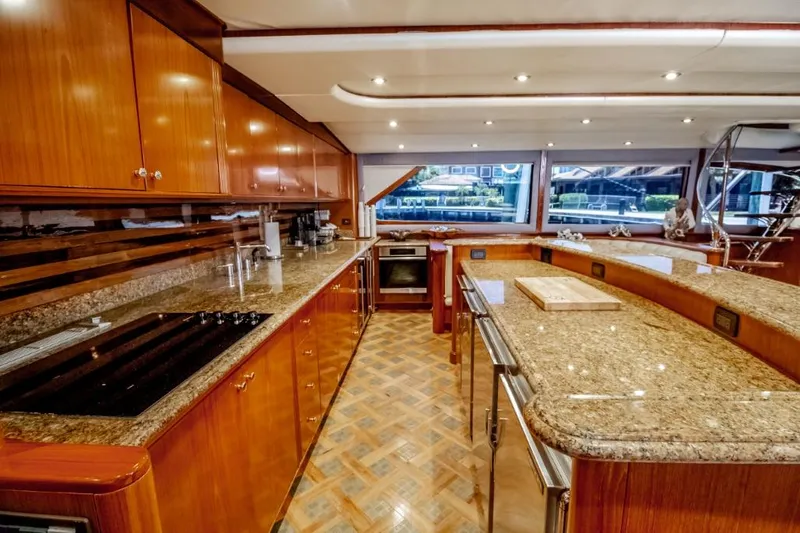 Reel Deal Yacht Photos Pics Luxurious 2005 Sea Force Sportfish yacht kitchen with granite countertops and wooden cabinetry.