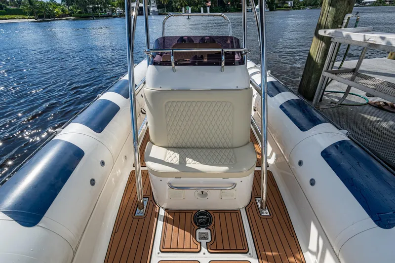 No Name Yacht Photos Pics 2023 Ocean Craft 38 boat interior with cushioned seating and teak flooring by the water.