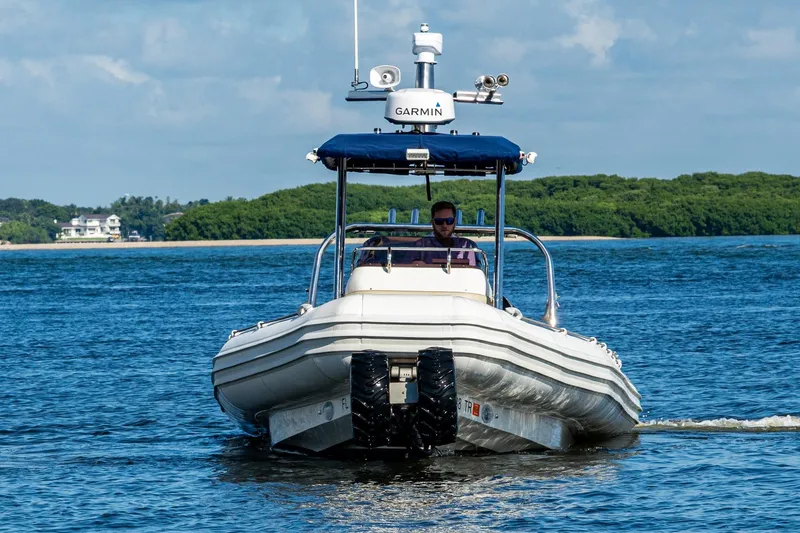 No Name Yacht Photos Pics 2023 Ocean Craft 38 boat navigating calm waters with lush green shoreline.