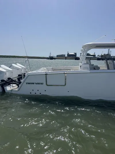 Yacht Photos Pics 2024 Twin Vee 400 GFX boat on water, side view, clear sky background.