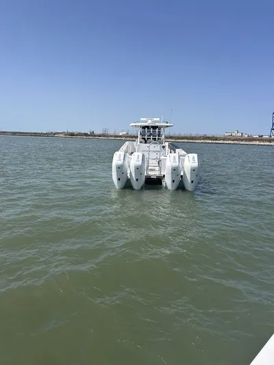  Yacht Photos Pics 2024 Twin Vee 400 GFX catamaran on calm water under clear blue sky.