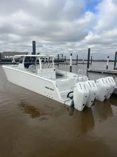  Yacht Photos Pics 2024 Twin Vee 400 GFX boat with triple engines docked under cloudy skies.