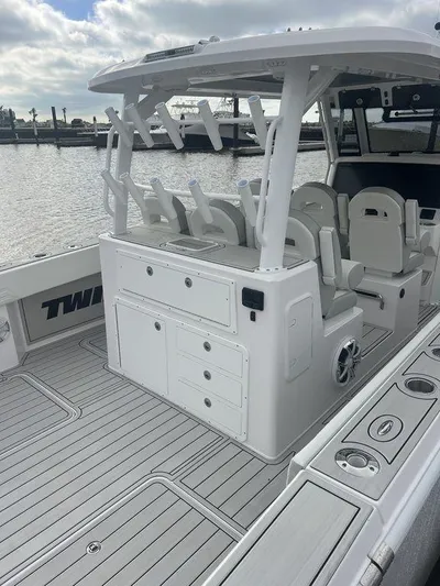  Yacht Photos Pics 2024 Twin Vee 400 GFX boat interior with seating and storage, docked by the water.