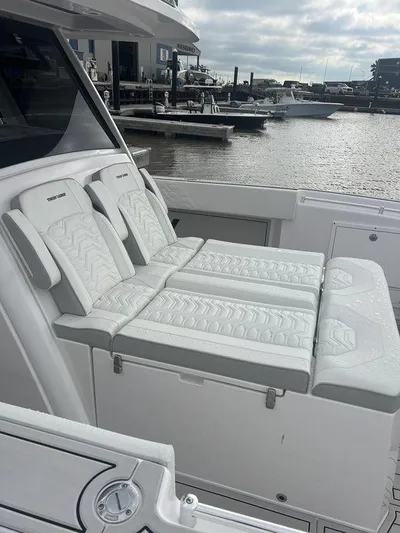  Yacht Photos Pics 2024 Twin Vee 400 GFX boat with luxurious white seating, docked at a marina.