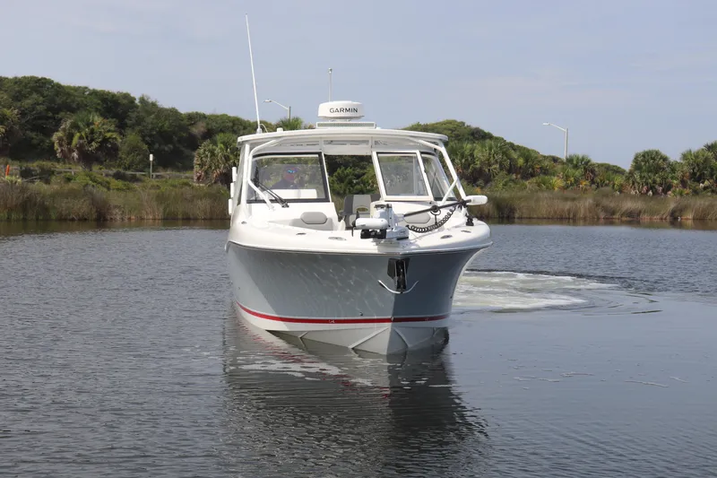 Reel Grateful Yacht Photos Pics 2021 Albemarle 31 DC boat on calm water, surrounded by lush greenery.