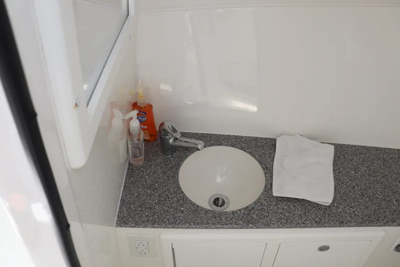 Reel Grateful Yacht Photos Pics Bathroom sink area in 2021 Albemarle 31 DC boat with toiletries and towel.