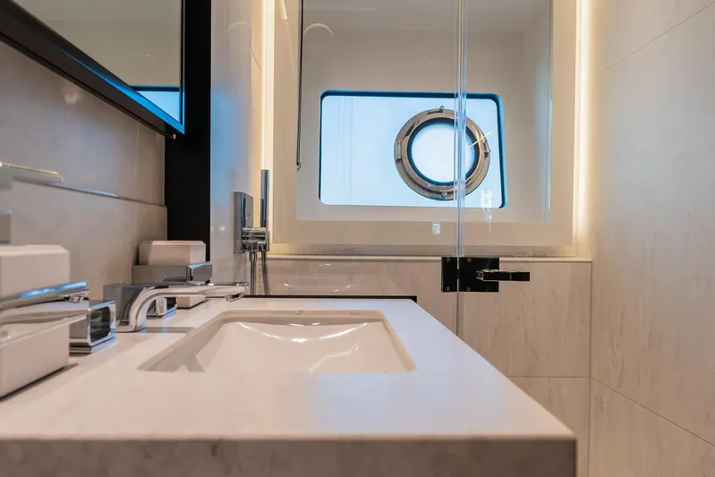  Yacht Photos Pics Luxury bathroom in 2025 Sunseeker 90 Ocean yacht with modern fixtures and porthole window.