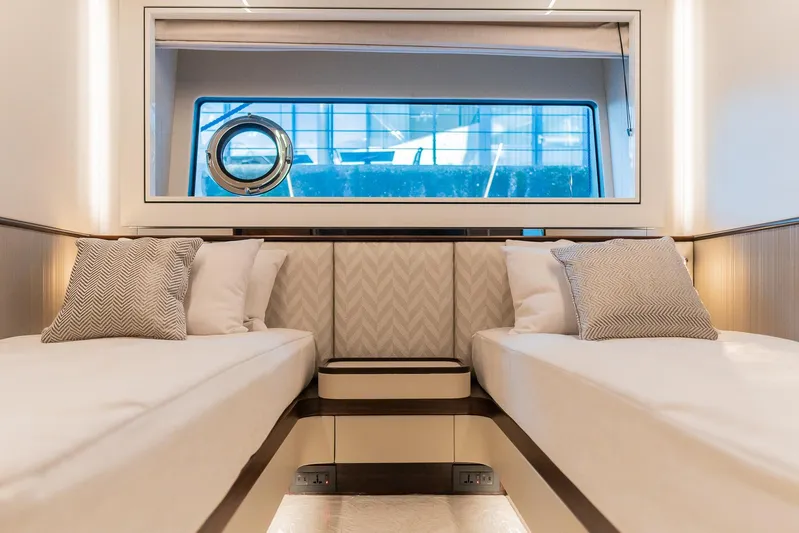  Yacht Photos Pics Luxurious twin cabin interior of 2025 Sunseeker 90 Ocean yacht with elegant bedding and window view.