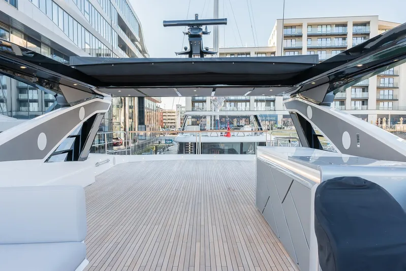  Yacht Photos Pics Luxurious 2025 Sunseeker 90 Ocean yacht deck with modern design and cityscape backdrop.