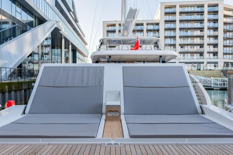  Yacht Photos Pics Luxurious Sunseeker 90 Ocean 2025 yacht with spacious sun loungers in a modern marina setting.