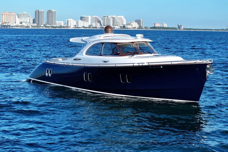 Our Trade Yacht Photos Pics 2013 Zeelander Z44 yacht cruising on blue ocean with city skyline in background.