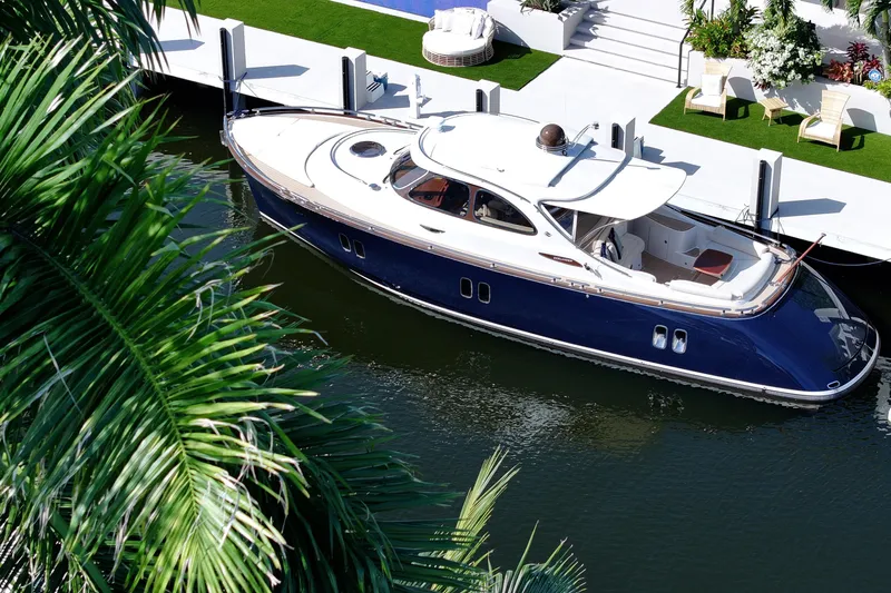 Our Trade Yacht Photos Pics 2013 Zeelander Z44 yacht docked by a luxurious waterfront, surrounded by lush greenery.