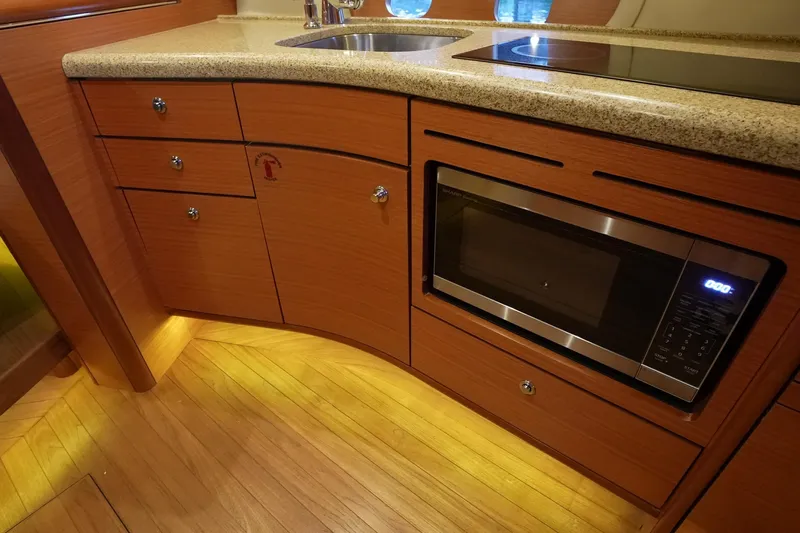 Our Trade Yacht Photos Pics Luxurious 2013 Zeelander Z44 yacht kitchen with wood cabinetry, microwave, and modern appliances.