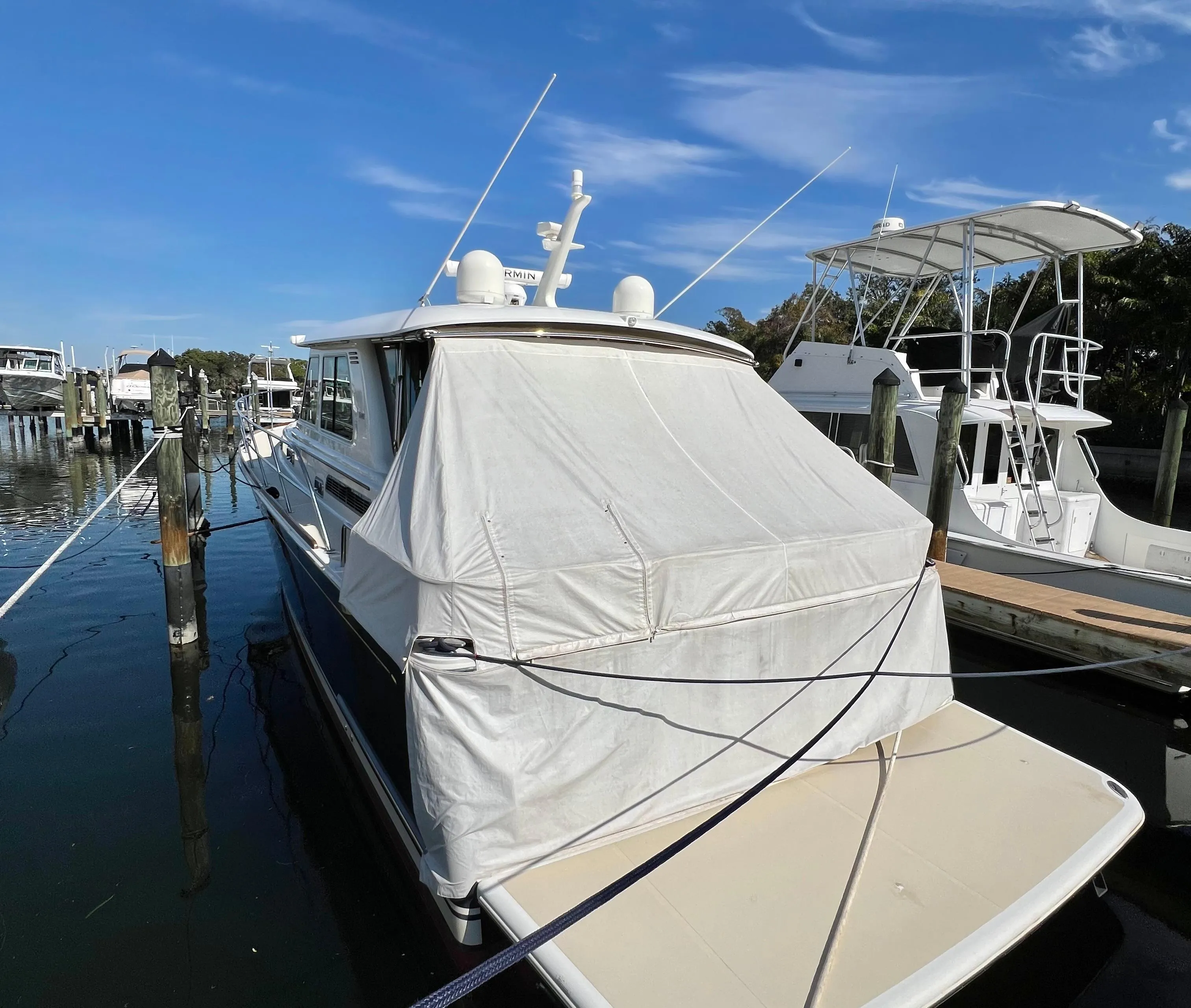 2017 Sabre 48 Salon Express yacht docked with cover, under clear blue sky.