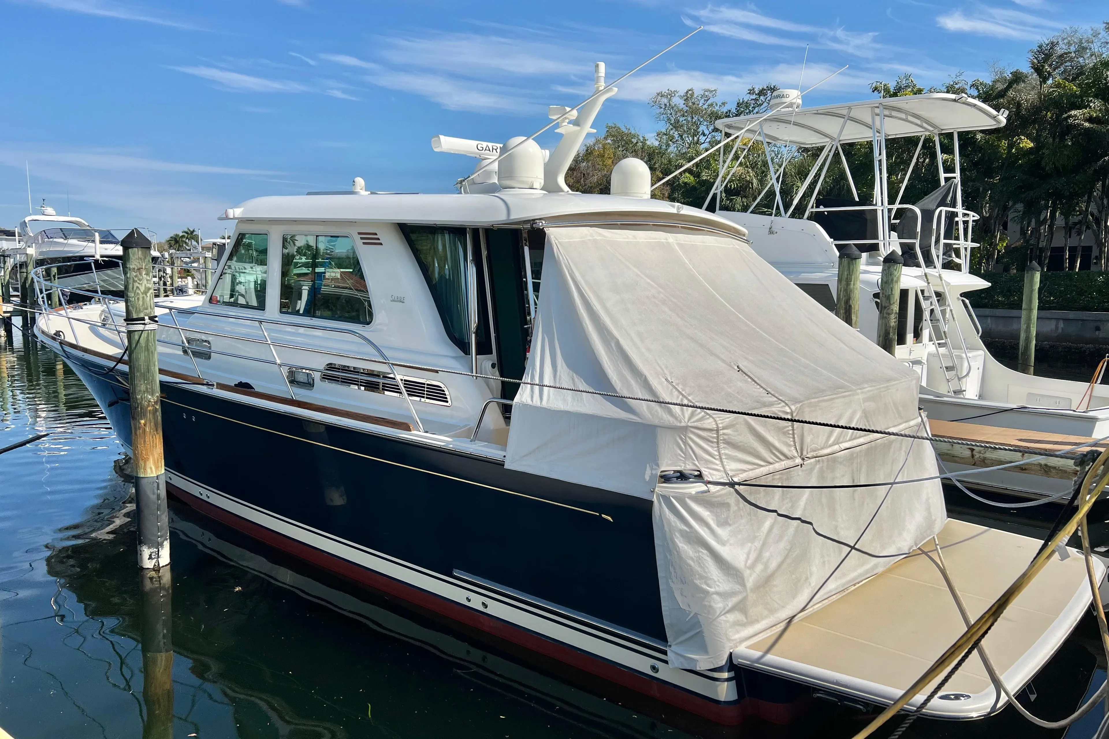 2017 Sabre 48 Salon Express yacht docked at marina under clear blue sky.