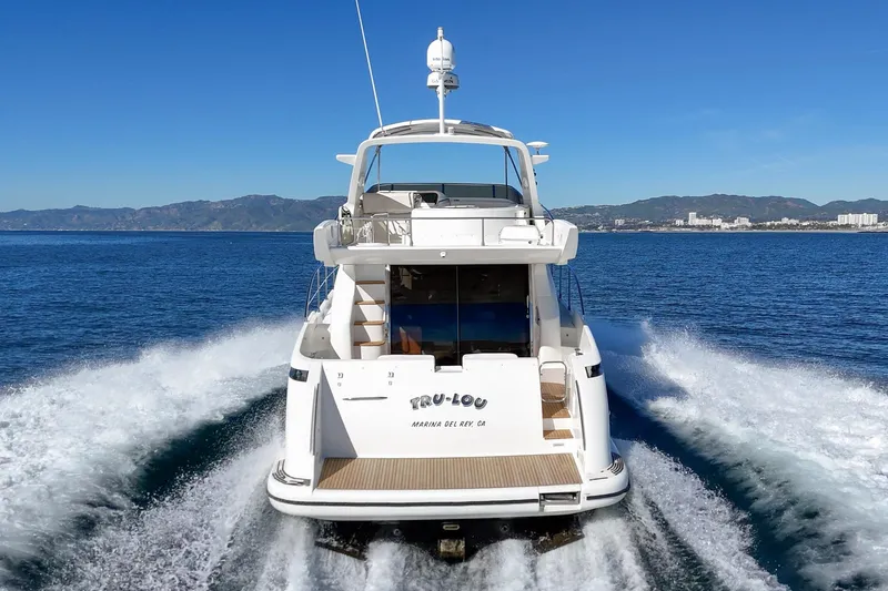  Yacht Photos Pics Azimut 58 yacht cruising on open water, 2002 model, scenic coastal backdrop.