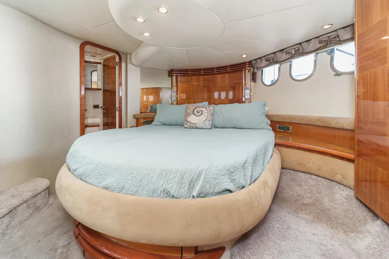  Yacht Photos Pics Luxurious 2002 Azimut 58 yacht bedroom with round bed and elegant wood accents.