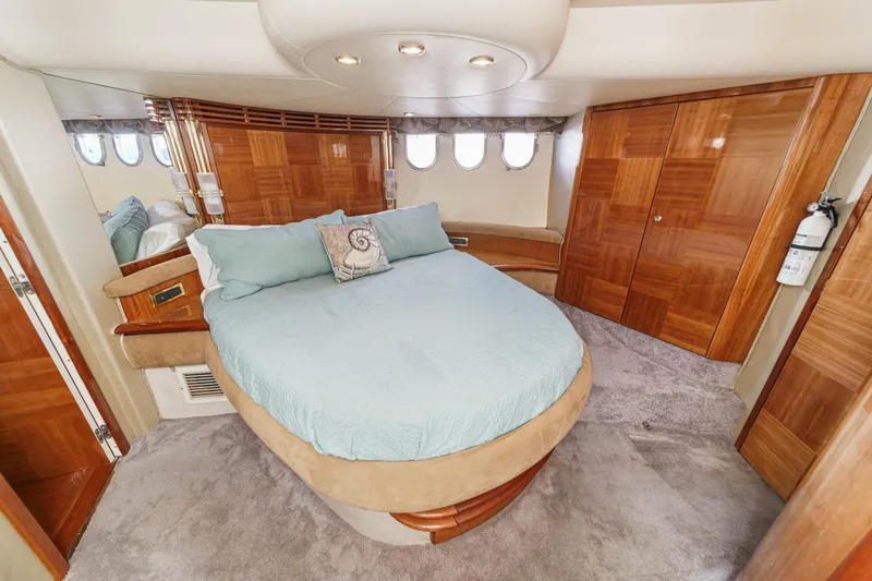  Yacht Photos Pics Luxurious 2002 Azimut 58 yacht bedroom with elegant wood finishes and plush bedding.