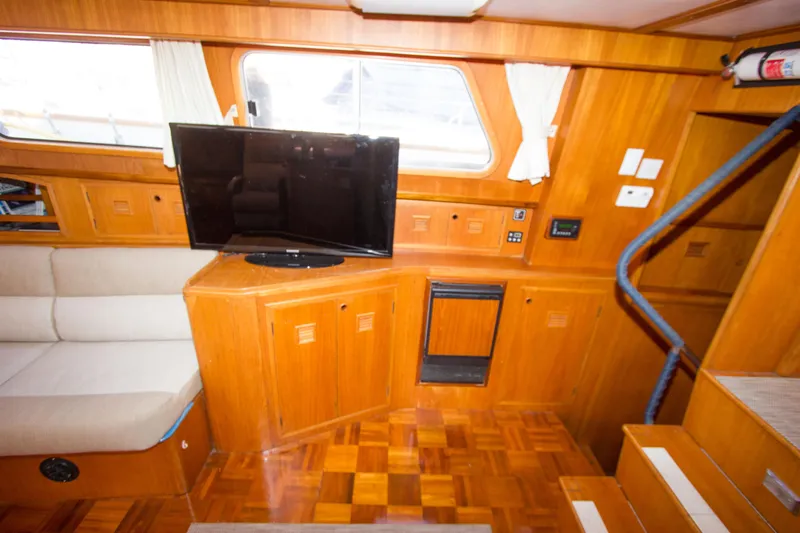 Seascape Yacht Photos Pics Interior of 1989 Cheoy Lee 53 yacht with wood paneling and a mounted TV.