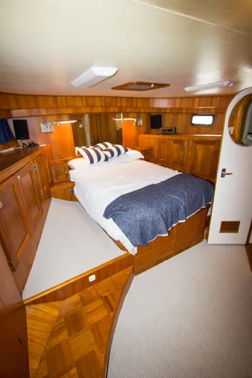 Seascape Yacht Photos Pics Luxurious 1989 Cheoy Lee 53 yacht bedroom with wood paneling and cozy bedding.