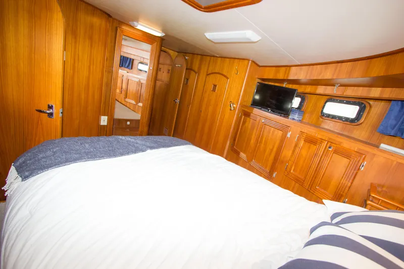 Seascape Yacht Photos Pics Luxurious cabin interior of 1989 Cheoy Lee 53 yacht with wood paneling and cozy bedding.