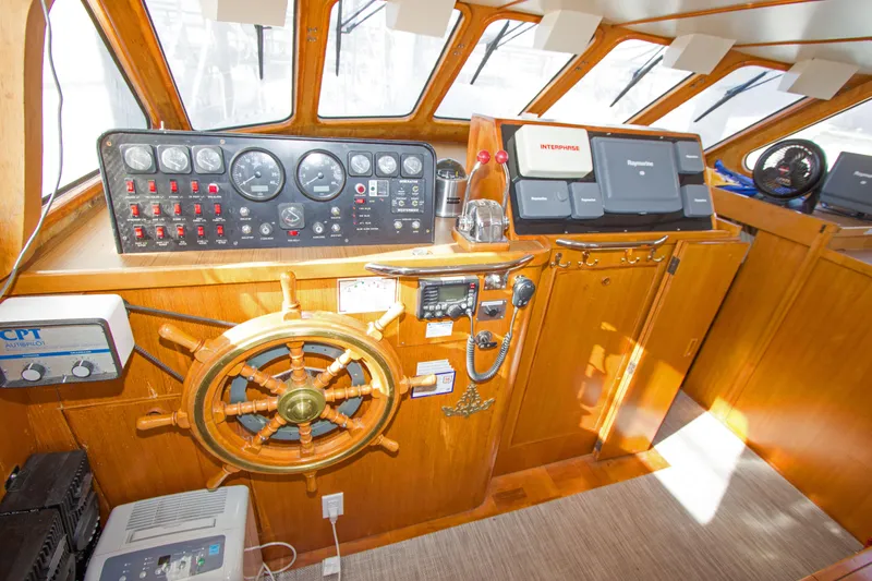 Seascape Yacht Photos Pics Interior helm of 1989 Cheoy Lee 53 yacht with wooden steering wheel and control panel.
