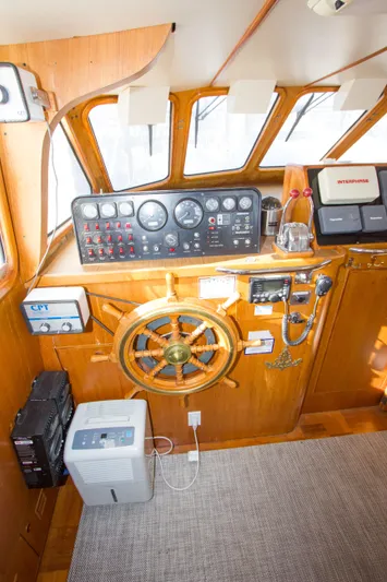 Seascape Yacht Photos Pics Interior helm of 1989 Cheoy Lee 53 yacht with wooden steering wheel and navigation instruments.