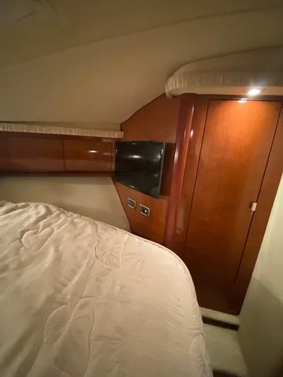  Yacht Photos Pics Interior cabin of 2006 Sea Ray 44 Sundancer yacht with wood paneling and bed.