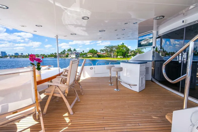 Serenity Yacht Photos Pics Luxurious 2008 Lazzara motor yacht deck with seating, bar, and scenic waterfront view.