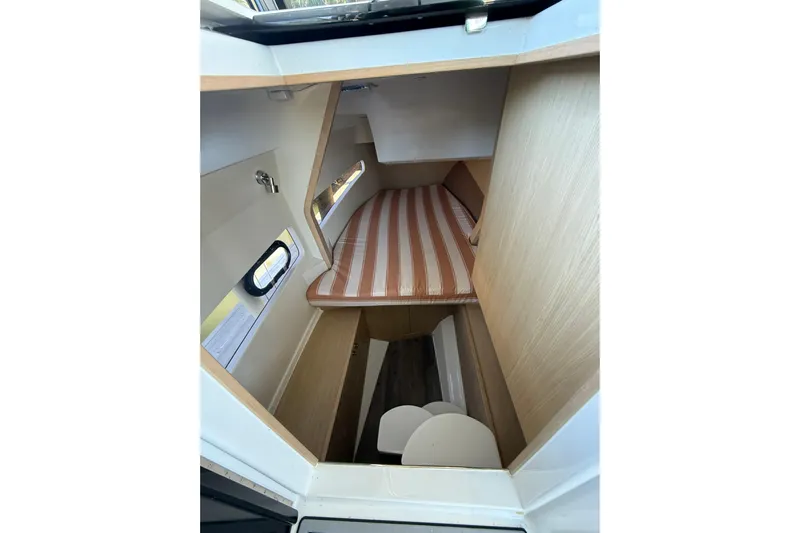  Yacht Photos Pics Interior cabin of 2021 Aquila 32 Sport boat with striped bedding.