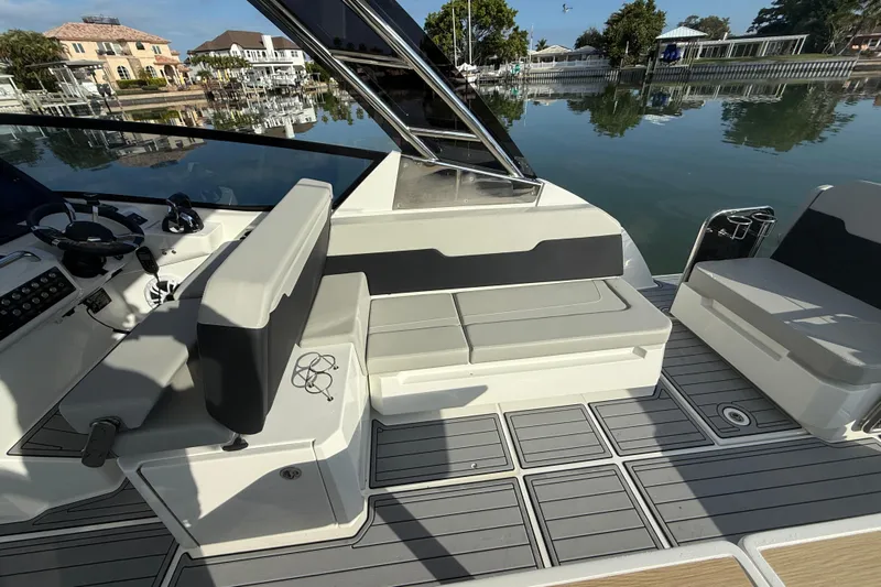  Yacht Photos Pics Aquila 32 Sport 2021 boat interior with seating and control panel, docked by waterfront homes.
