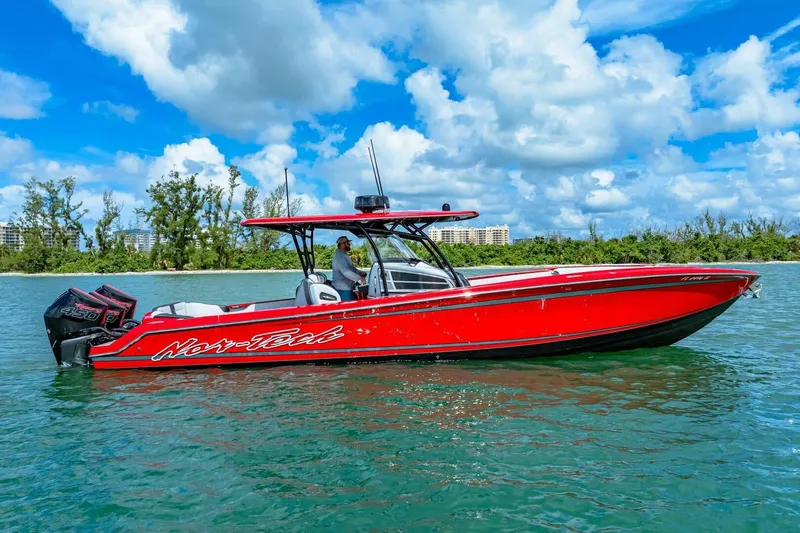  Yacht Photos Pics 2022 Nor-Tech 390 SS boat in vibrant red on clear blue water.