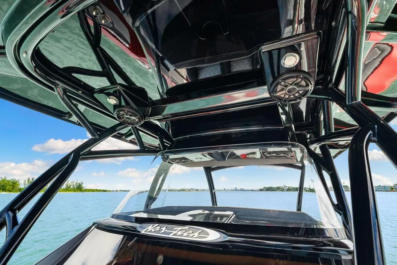  Yacht Photos Pics 2022 Nor-Tech 390 SS boat interior with sleek black design and speakers, overlooking serene water.