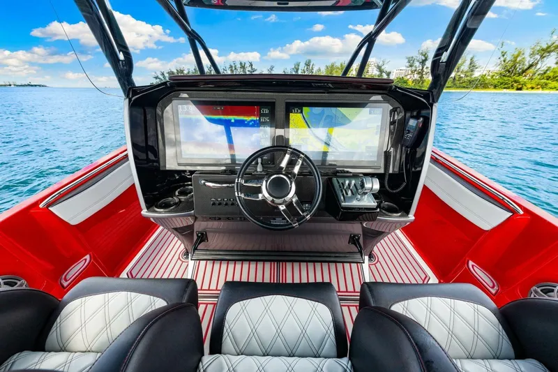  Yacht Photos Pics 2022 Nor-Tech 390 SS boat cockpit with modern navigation system, red and white interior.