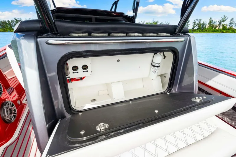  Yacht Photos Pics 2022 Nor-Tech 390 SS boat storage compartment with open hatch, featuring sleek design and ocean backdrop.
