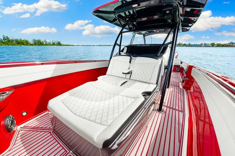  Yacht Photos Pics 2022 Nor-Tech 390 SS boat with luxurious white seating and vibrant red accents on the water.