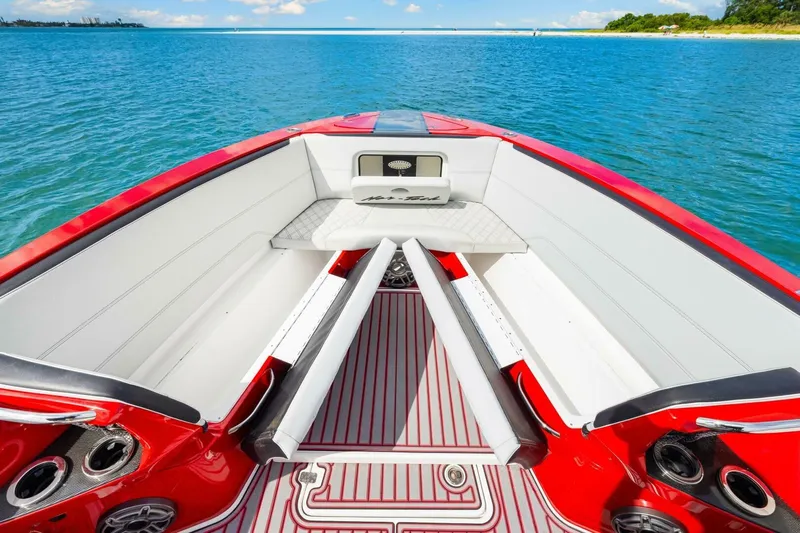  Yacht Photos Pics 2022 Nor-Tech 390 SS boat interior with red and white seating, on a serene blue water backdrop.