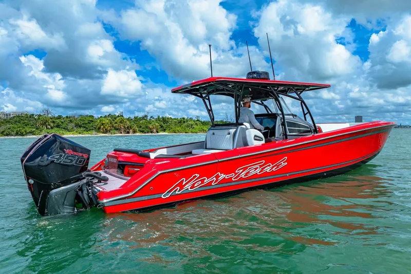  Yacht Photos Pics 2022 Nor-Tech 390 SS boat in vibrant red on water, with powerful outboard engine.