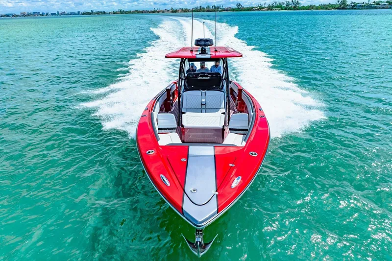  Yacht Photos Pics 2022 Nor-Tech 390 SS boat cruising on clear turquoise water, showcasing sleek red design.