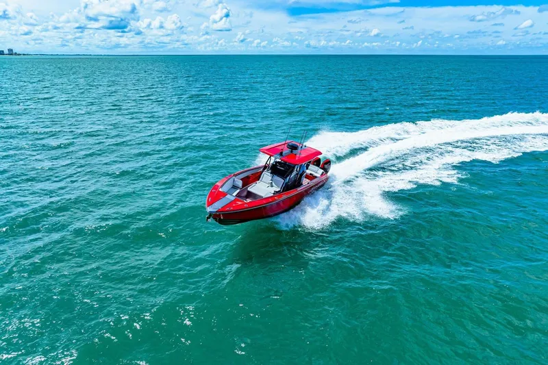  Yacht Photos Pics Red 2022 Nor-Tech 390 SS boat cruising on open blue ocean under clear sky.