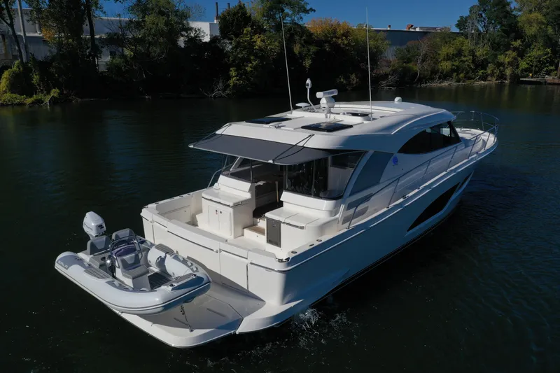  Yacht Photos Pics 2025 Riviera 465 SUV yacht cruising on a serene river.