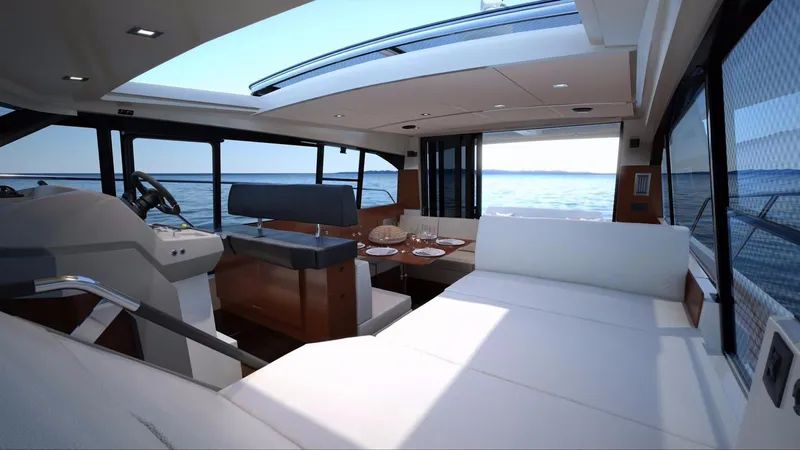 Bee's Knees Yacht Photos Pics Manufacturer Provided Image: Interior of 2017 Jeanneau NC 14 yacht with ocean view and modern seating.