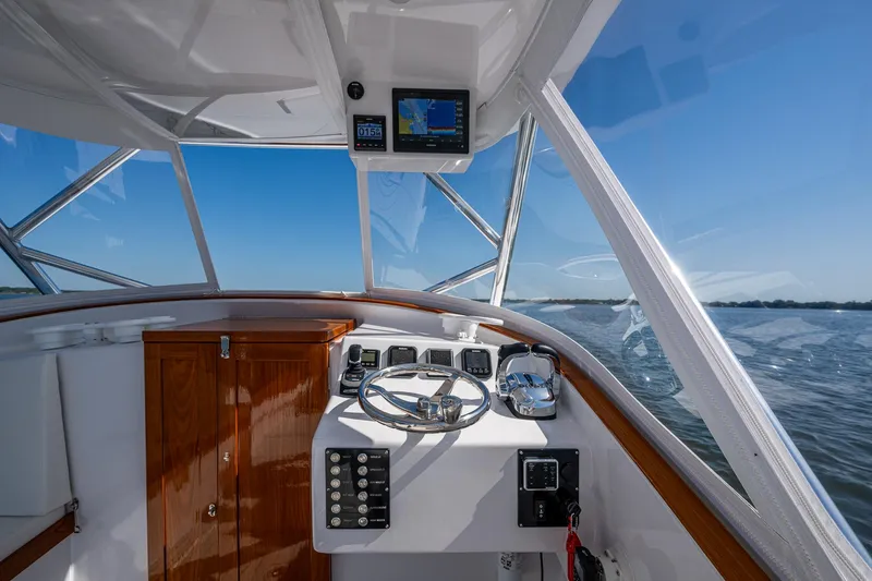 Dreams Afloat Yacht Photos Pics 2019 Custom Carolina Custom Express boat helm with navigation system, steering wheel, and ocean view.