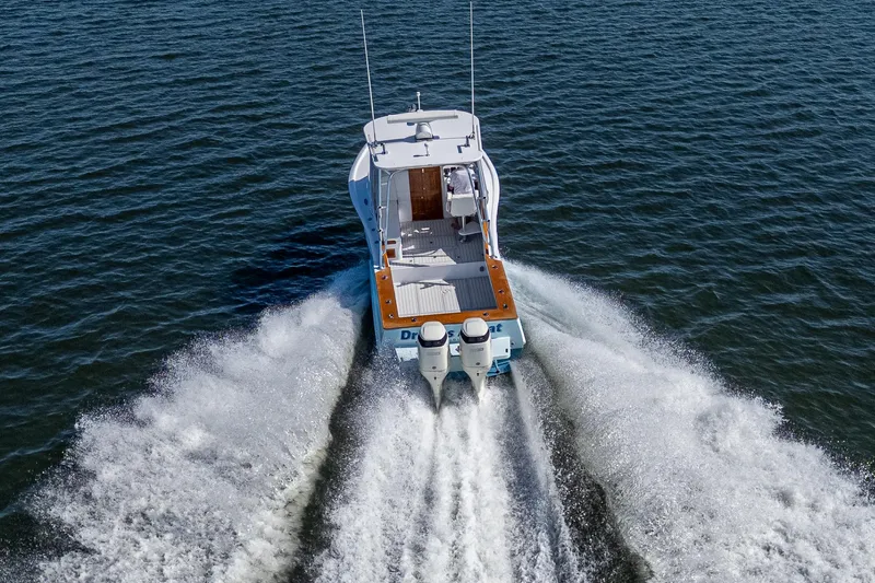 Dreams Afloat Yacht Photos Pics 2019 Custom Carolina Custom Express boat cruising on open water, rear view.