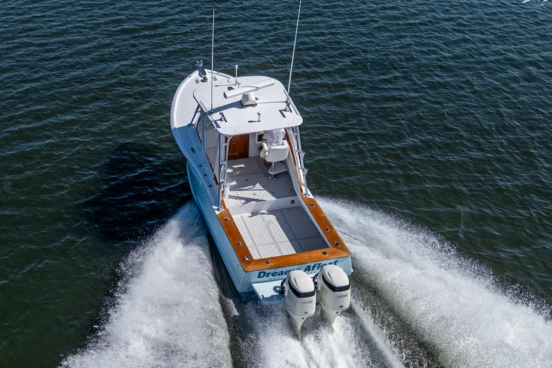 Dreams Afloat Yacht Photos Pics 2019 Custom Carolina Custom Express boat cruising on open water, rear view.