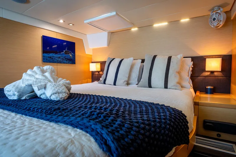 Bluewinds Yacht Photos Pics Luxurious bedroom interior of 2023 Lagoon 560 S2 yacht with elegant decor and ambient lighting.