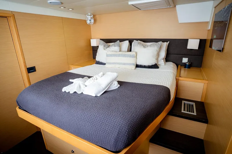 Bluewinds Yacht Photos Pics Luxurious bedroom interior of 2023 Lagoon 560 S2 yacht with cozy bedding and modern design.